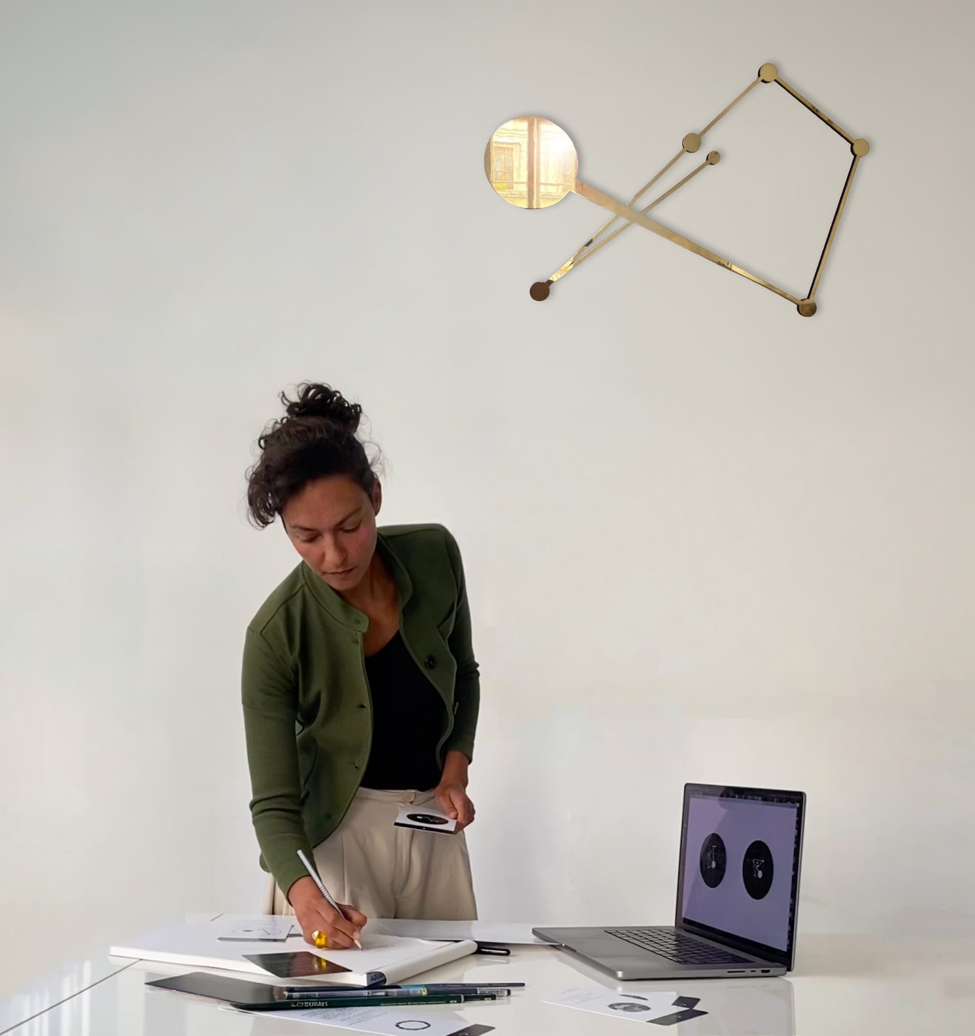 Vidya-Kélie dessinant à l'atelier sous une sculpture dorée